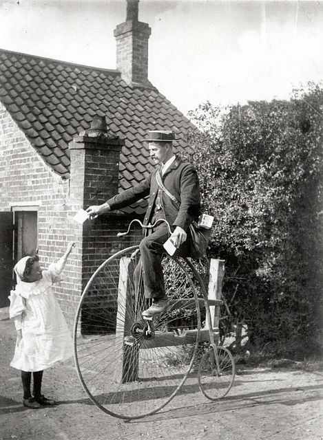 Historical bicycle postman delivering mail