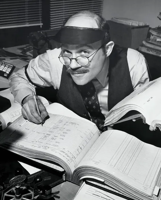 Businessman working at a desk covered with books and papers